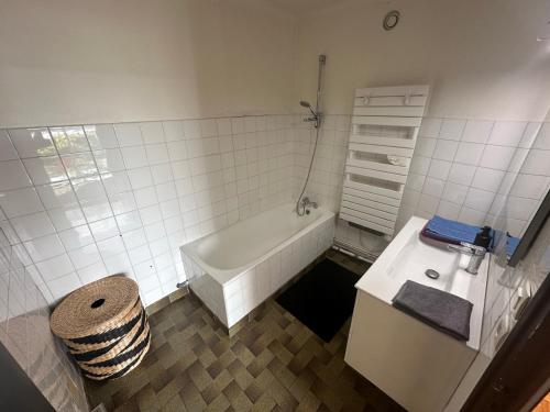 une salle de bain blanche avec une baignoire et un lavabo dans l'établissement Spacieux Lumineux Confort Terrasse, à Brest