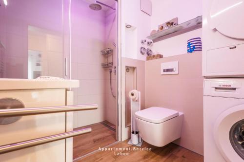 La salle de bains blanche est pourvue d'une douche et de toilettes. dans l'établissement Villa Fördestrand W06, à Laboe