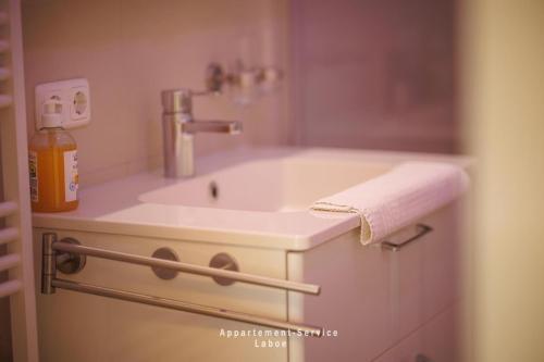 a bathroom with a white sink with a soap dispenser at Villa Fördestrand W06 in Laboe