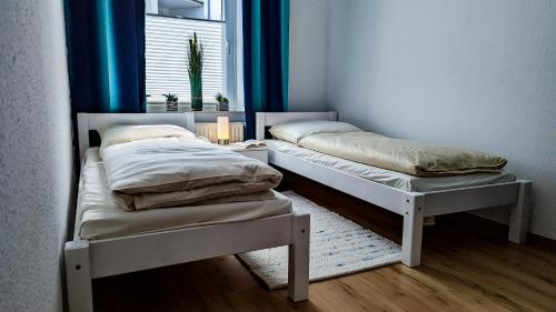 two twin beds in a room with a window at Fewo Sanddüne nur wenige Minuten vom Hafen und Strand entfernt in Laboe