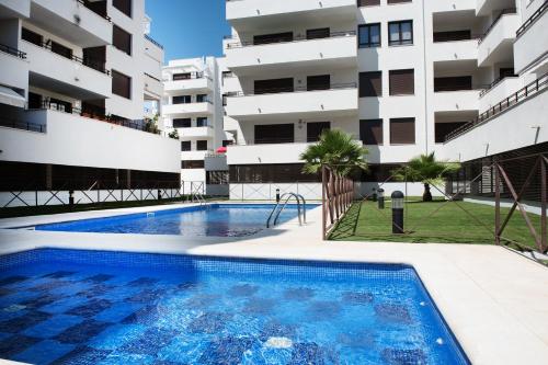 a swimming pool in front of a building at NEW APARTMENT WITH BIG TERRACE 10 Min WALK TO BEACH SUPERMARKETS in Calafell