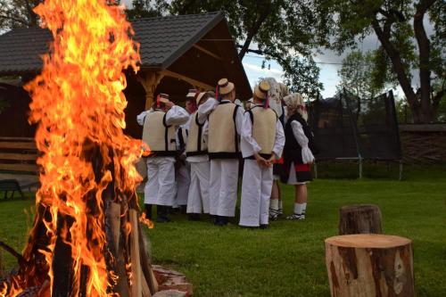 a group of men in uniform standing next to a fire at Pensiunea Maramu in Breb