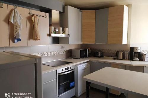 une cuisine avec des armoires blanches et un four à plaques de cuisson dans l'établissement Appartement 5 chambres proche de toute commodité, à Noisy-le-Grand