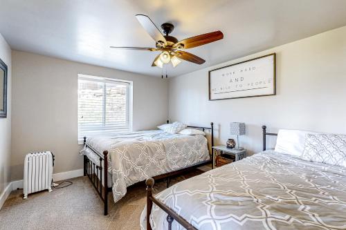 ein Schlafzimmer mit zwei Betten und einem Deckenventilator in der Unterkunft Buttercup Beauty in Garden City