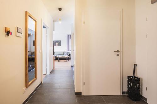 a hallway with white walls and a mirror at Nassfeld - SkiIn-SkiOut direkt an der Piste mit Sauna - Bergzauber9 in Hermagor