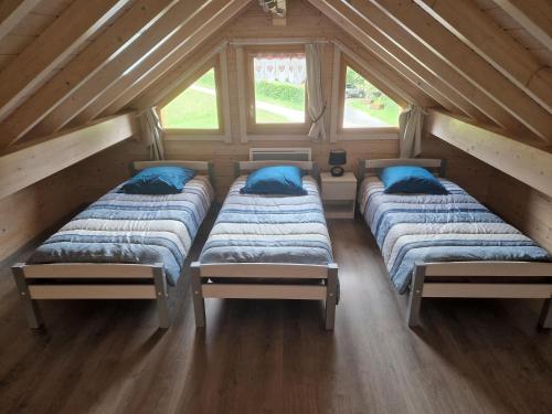 un gruppo di quattro letti in una soffitta di Chalet des platanes Entre l'Alsace et les Vosges Nature a La Grande Fosse