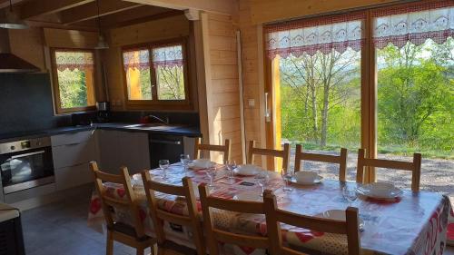 une salle à manger avec une table et des chaises et une cuisine dans l'établissement Chalet des platanes Entre l'Alsace et les Vosges Nature, à La Grande Fosse