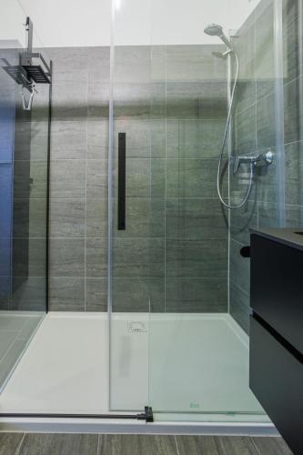 a shower with a glass door in a bathroom at Nassfeld - SkiIn-SkiOut direkt an der Piste mit Sauna - Bergzauber9 in Hermagor