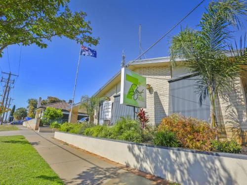a building with a sign next to a sidewalk at 7th Street Motel in Mildura