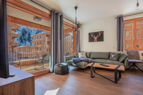 a living room with a couch and a large window at Nassfeld - SkiIn-SkiOut direkt an der Piste mit Sauna - Bergzauber9 in Hermagor