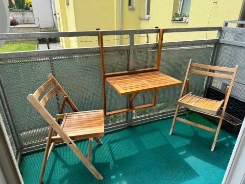 two chairs and a table on a balcony at Apartmán s garáží a balkónem in Plzeň