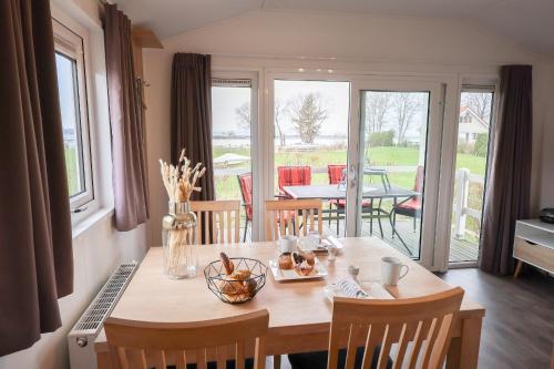 a dining room with a table with chairs and a dining room at Ferienhaus Ostseechalet Strandmuschel Gelting in Gelting