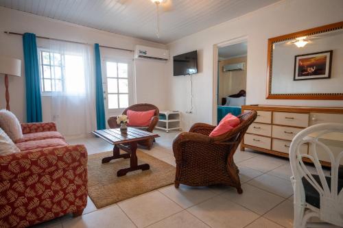 a living room with chairs and a coffee table at Aruba Sunrise 1BR Apt Near Baby Beach San Nicolas in Sint Nicolaas