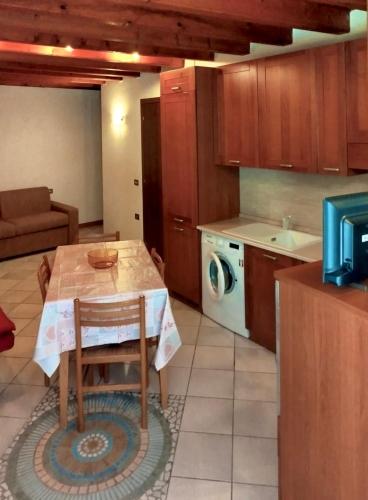a kitchen with a table and a washing machine at Nido tra castello e lago in Desenzano del Garda