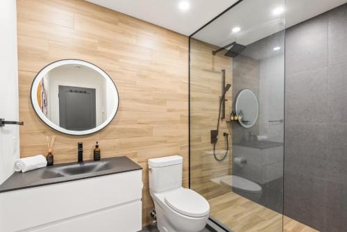 a bathroom with a toilet and a mirror at Tremblant Prestige - Les Eaux 235-1 in Mont-Tremblant