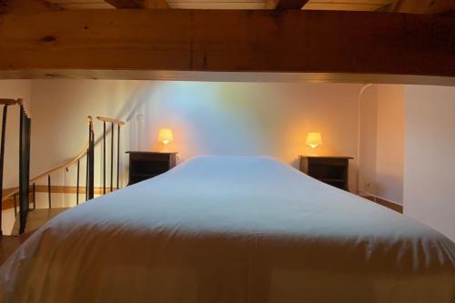 a bed in a room with two lights on the wall at Le XILOTIK - Peaceful apartment in Espelette in Espelette