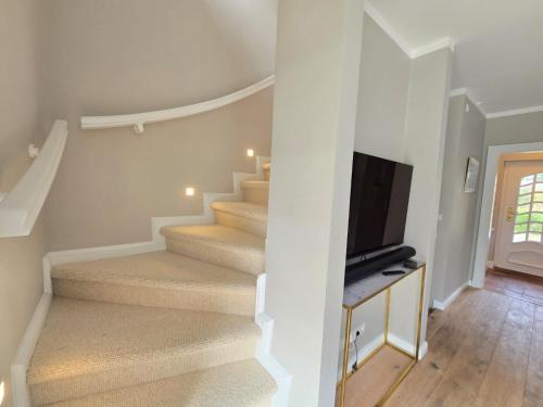 a staircase with a flat screen tv next to it at Ferienhaus Cäcilienhof Ost in Kampen