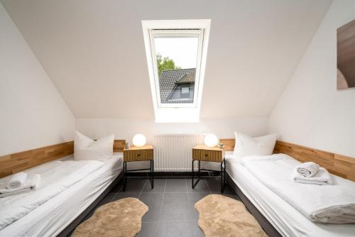 MarienfeldeにあるFerienwohung Müritzfreude OGのベッド2台と窓2つが備わる客室です。