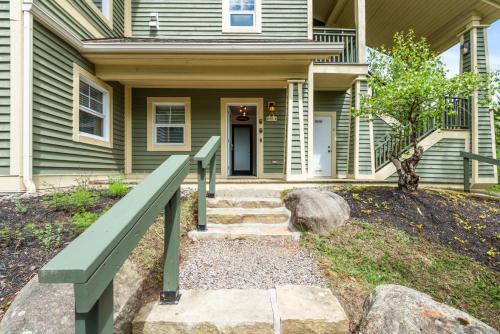 a home with a green house with a green rail at Tremblant Prestige - Les Eaux 235-1 in Mont-Tremblant