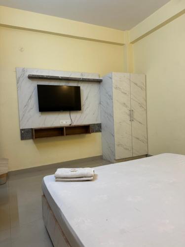 a room with a bed and a tv on a wall at Shomaan boutique hotel in Sundarnagar