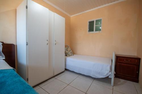 a bedroom with two beds and a closet and a window at Aruba Sunrise 1BR Apt Near Baby Beach San Nicolas in Sint Nicolaas