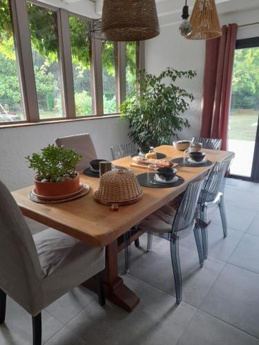 a dining room table with chairs and a wooden tableablish at Les Jardins de Lamourelle chambre Prairie in Lacquy