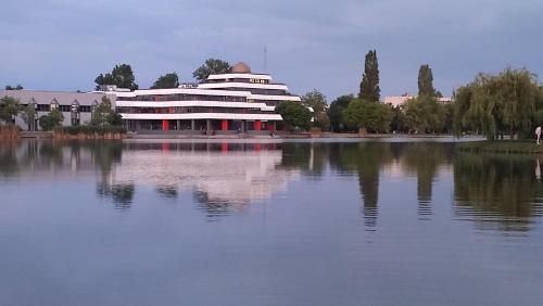 a large building sitting on top of a large body of water at Fehérvár Cappuccino apartman City center, AC, Easy Parking in Székesfehérvár