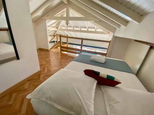 Schlafzimmer mit einem weißen Bett und einem roten Kissen in der Unterkunft Superbe villa proche de la plage in Sainte-Anne