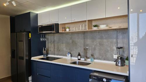 a kitchen with a sink and a refrigerator at Depto Centro de Monterrey by tuhost in Monterrey