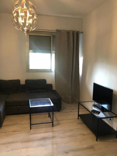 un salon avec un canapé et une table dans l'établissement Joli studio, à Marseille
