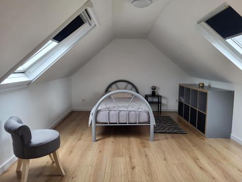 ブリュッセルにあるBrussels Bed & Blockchain Private rooms with shared bathroomのベッドと椅子付きの屋根裏部屋