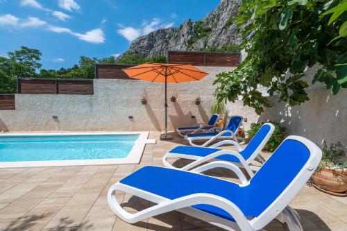 Un grupo de sillas y una sombrilla junto a una piscina. en Apartment Marina on the second floor, en Makarska
