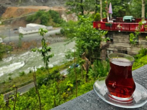 a glass of soda sitting on a plate on a table at Zayna bungalov in Çamlıhemşin