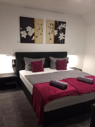 a bedroom with a large bed with red sheets at Haus Gerry in Düsseldorf