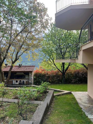 a building with a balcony and a yard with trees at Ανάμεσα στα Έλατα in Ayía Varvára