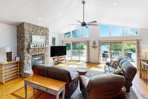 a living room with leather furniture and a stone fireplace at Plum Paradise in Glenora
