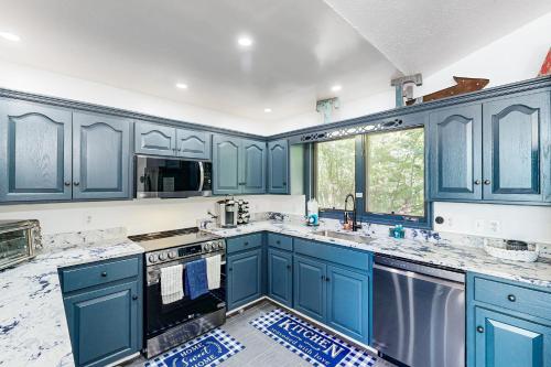 a blue kitchen with marble counter tops and blue cabinets at Plum Paradise in Glenora