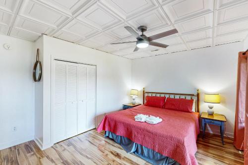 a bedroom with a red bed and a ceiling fan at Plum Paradise in Glenora