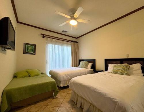 a bedroom with two beds and a ceiling fan at Near Marina Luxury Condo with Pool, Gym, Gold and more in Herradura