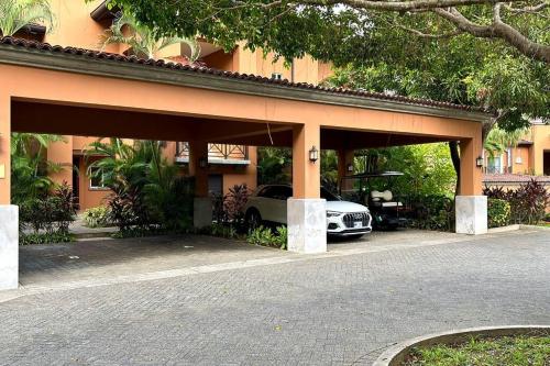 a car is parked under a building with a car garage at Near Marina Luxury Condo with Pool, Gym, Gold and more in Herradura