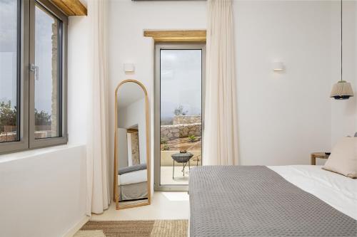 a bedroom with a large window and a mirror at FENNEL Villas in Marathi