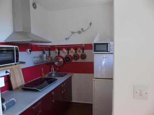 une petite cuisine avec un évier et un réfrigérateur dans l'établissement idéal curiste, à Gréoux-les-Bains