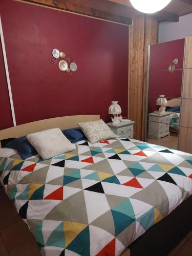een slaapkamer met een kleurrijk dekbed op een bed bij Dominique et Françoise in Fourques-sur-Garonne