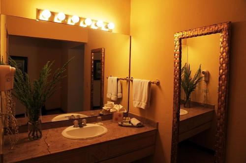 a bathroom with a sink and a large mirror at Hotel Portal del Angel in Tegucigalpa