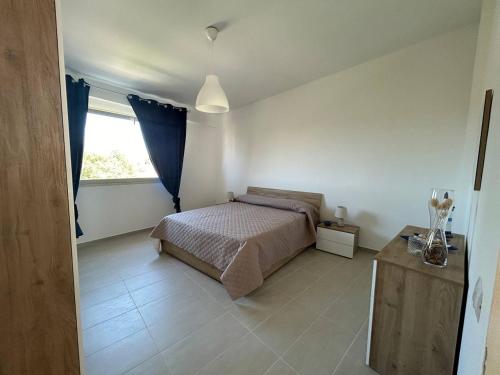 een slaapkamer met een bed en een raam bij La terrazza della Dolce Casa - Blue Wave - Casuzze in Villaggio Azzurro