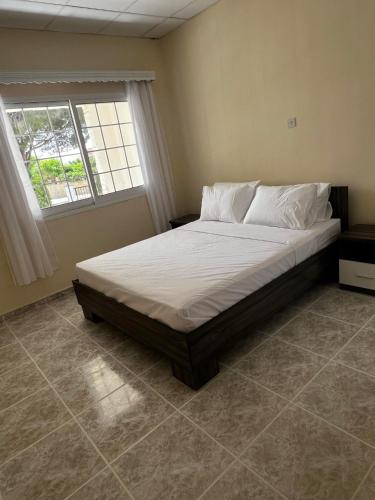 a large bed in a bedroom with a window at villa 58 coral bay seafront in Peyia