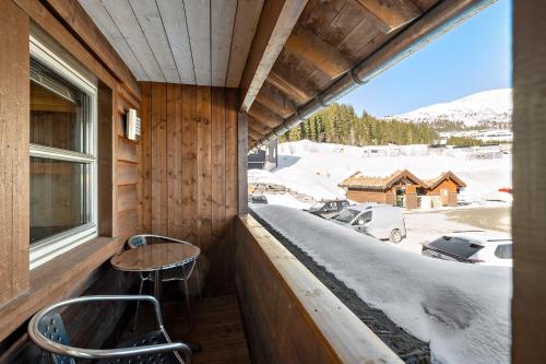 einen Balkon mit einem Tisch und Stühlen sowie einem Fenster in der Unterkunft Voss Resort Bavallstunet in Skulestadmo