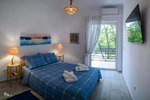 a bedroom with a blue bed with two towels on it at Blue Ocean Luxury House in Nea Makri