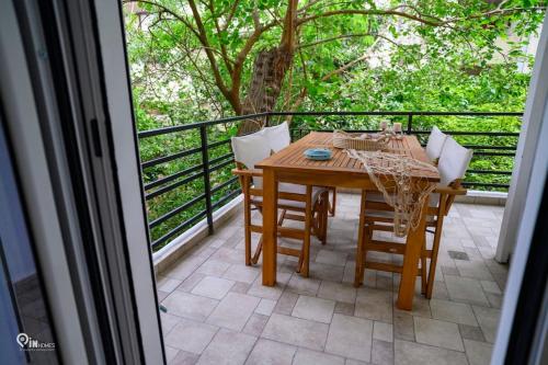 a wooden table and chairs on a balcony at Blue Ocean Luxury House in Nea Makri