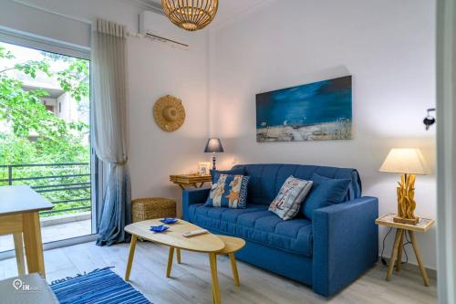 a living room with a blue couch and a table at Blue Ocean Luxury House in Nea Makri